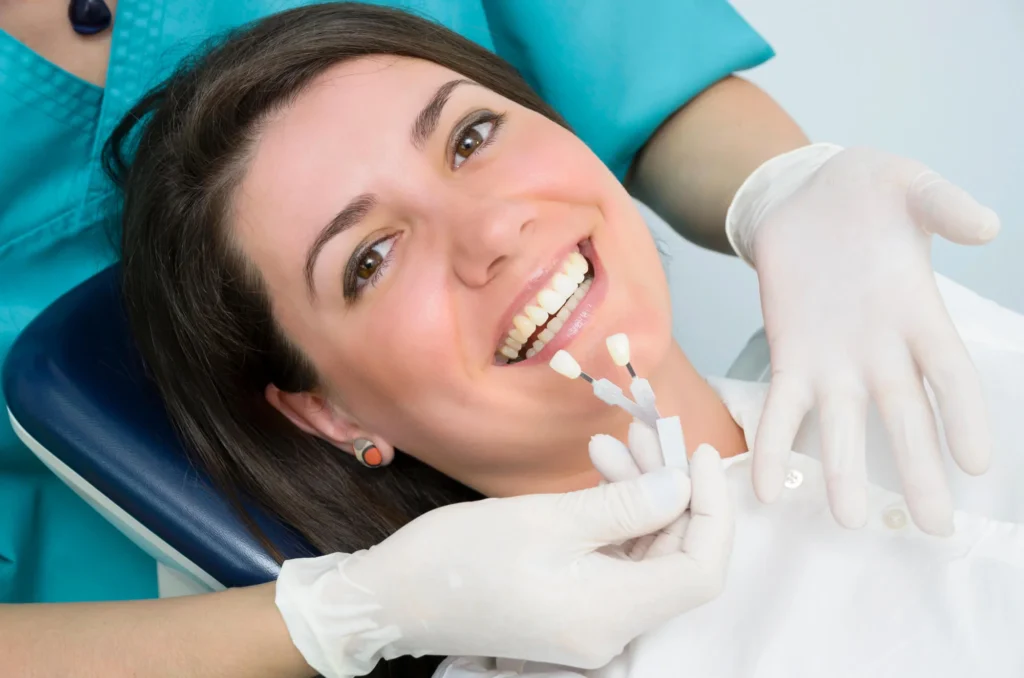 Dentist helping a female patient choose a shade for dental implants in Panama City FL.