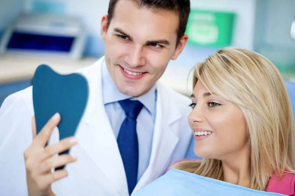 Patient checking results of dental bridges in Panama City, FL