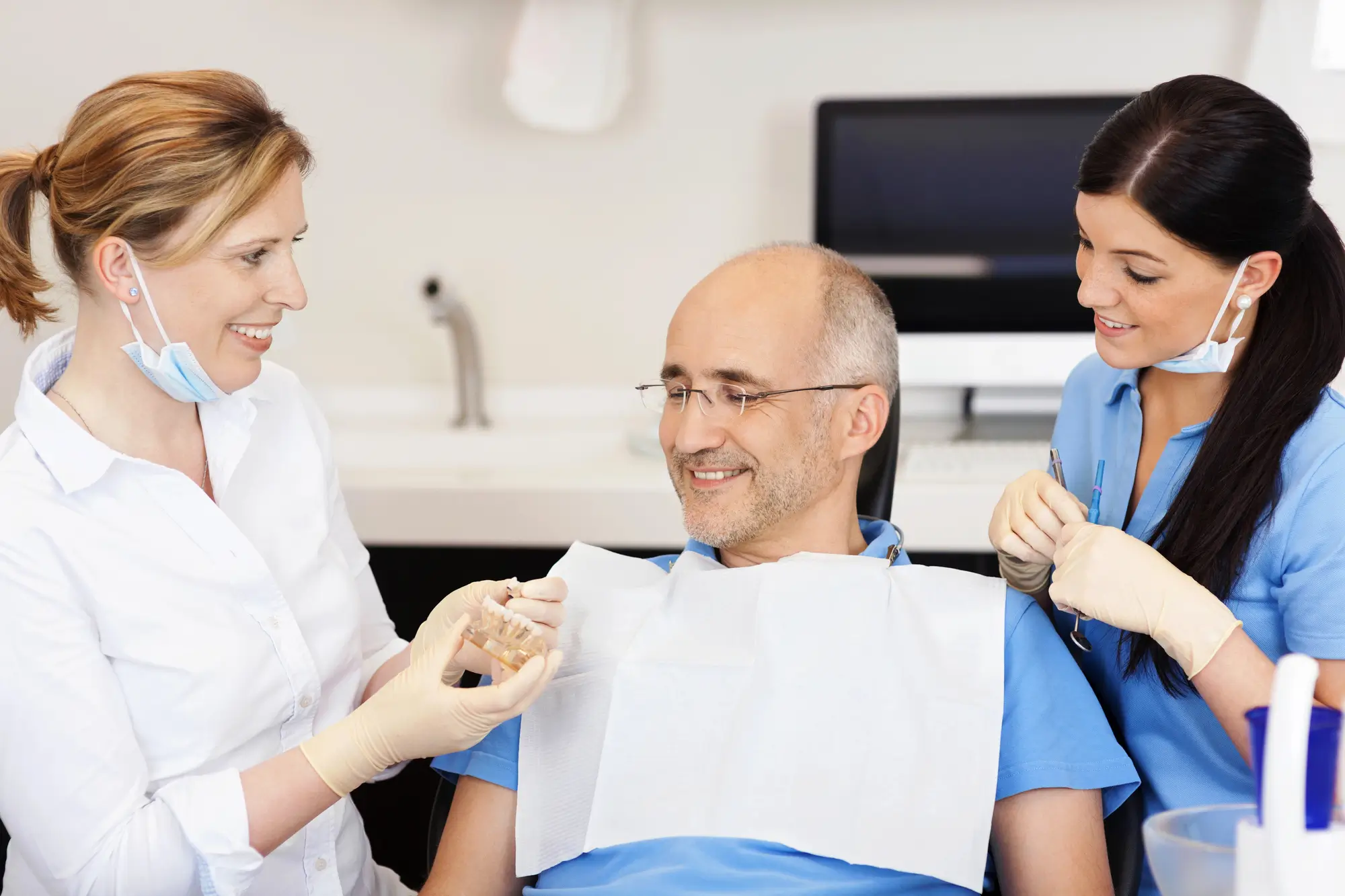 Dentist explaining teeth model for tooth crowns in Panama City, FL